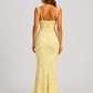 Woman wearing a floral maxi dress with delicate ruffle straps, slim-fit silhouette, flowing lightweight fabric, and romantic summer styling.