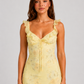 Woman wearing a floral maxi dress with delicate ruffle straps, slim-fit silhouette, flowing lightweight fabric, and romantic summer styling.