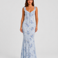 Woman wearing a floral maxi dress with delicate ruffle straps, slim-fit silhouette, flowing lightweight fabric, and romantic summer styling.