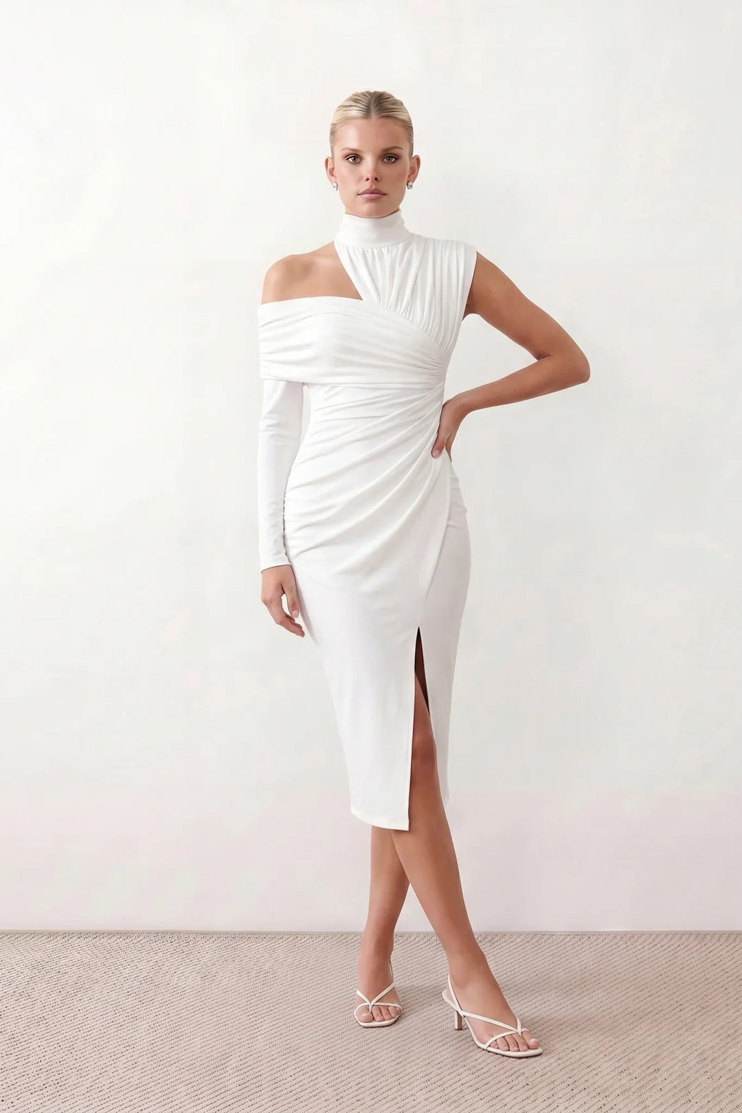 Woman wearing the Felisa Asymmetric Neck Open Back Midi Dress featuring an asymmetric mock-neck halter, off-shoulder ruched detailing, long fitted sleeves, an elegant open back, fitted midi silhouette and front slit, styled for weddings, cocktail parties and formal occasions.