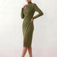 Woman wearing the Asymmetric Neck Open Back Midi Dress featuring an asymmetric mock-neck halter, off-shoulder ruched detailing, long fitted sleeves, an elegant open back, fitted midi silhouette and front slit, styled for weddings, cocktail parties and formal occasions.