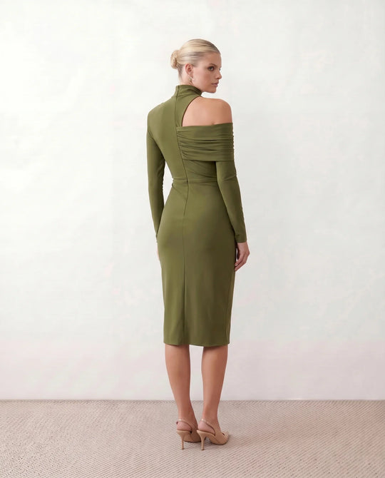Woman wearing the Felisa Asymmetric Neck Open Back Midi Dress featuring an asymmetric mock-neck halter, off-shoulder ruched detailing, long fitted sleeves, an elegant open back, fitted midi silhouette and front slit, styled for weddings, cocktail parties and formal occasions.