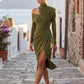 Woman wearing the Asymmetric Neck Open Back Midi Dress featuring an asymmetric mock-neck halter, off-shoulder ruched detailing, long fitted sleeves, an elegant open back, fitted midi silhouette and front slit, styled for weddings, cocktail parties and formal occasions.