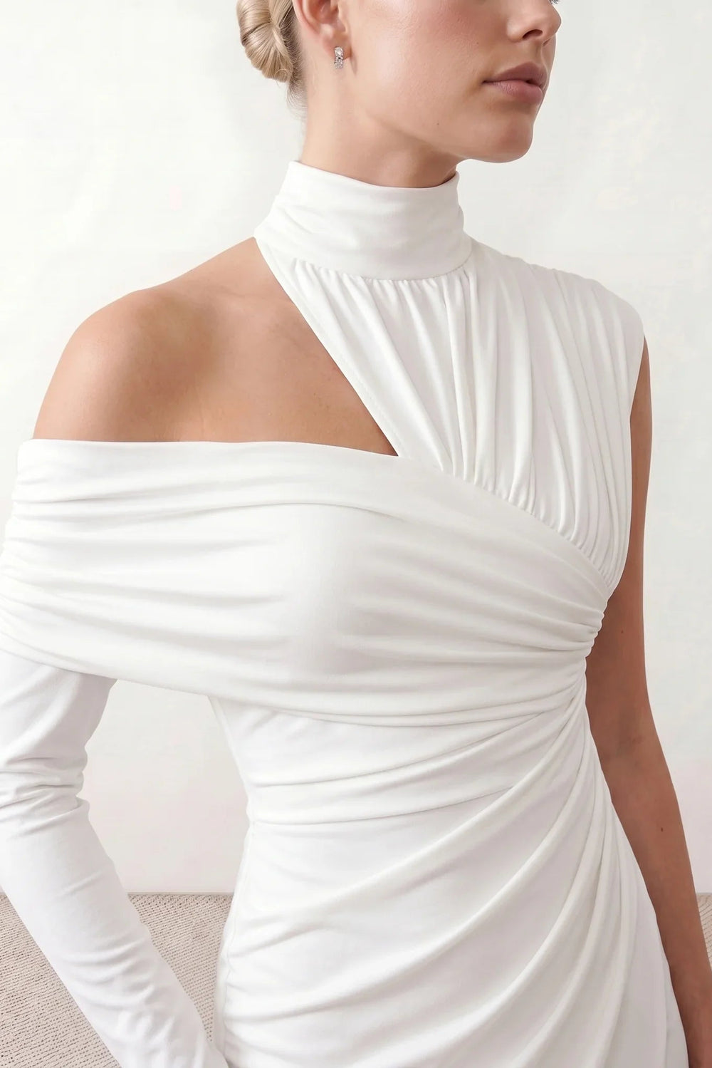 Woman wearing the Felisa Asymmetric Neck Open Back Midi Dress featuring an asymmetric mock-neck halter, off-shoulder ruched detailing, long fitted sleeves, an elegant open back, fitted midi silhouette and front slit, styled for weddings, cocktail parties and formal occasions.