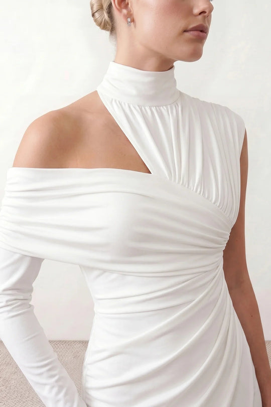 Woman wearing the Felisa Asymmetric Neck Open Back Midi Dress featuring an asymmetric mock-neck halter, off-shoulder ruched detailing, long fitted sleeves, an elegant open back, fitted midi silhouette and front slit, styled for weddings, cocktail parties and formal occasions.