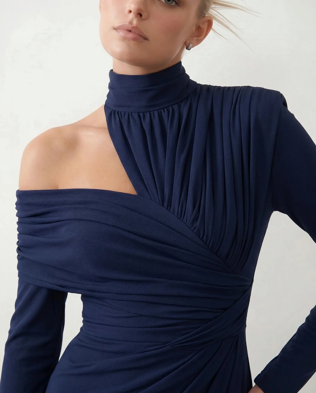 Woman wearing the Felisa Asymmetric Neck Open Back Midi Dress featuring an asymmetric mock-neck halter, off-shoulder ruched detailing, long fitted sleeves, an elegant open back, fitted midi silhouette and front slit, styled for weddings, cocktail parties and formal occasions.