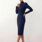 Woman wearing the Asymmetric Neck Open Back Midi Dress featuring an asymmetric mock-neck halter, off-shoulder ruched detailing, long fitted sleeves, an elegant open back, fitted midi silhouette and front slit, styled for weddings, cocktail parties and formal occasions.