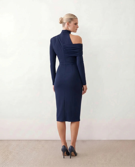Woman wearing the Felisa Asymmetric Neck Open Back Midi Dress featuring an asymmetric mock-neck halter, off-shoulder ruched detailing, long fitted sleeves, an elegant open back, fitted midi silhouette and front slit, styled for weddings, cocktail parties and formal occasions.