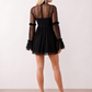Women's Yasmine Flower Appliqué Mini Dress featuring delicate floral appliqué across the bodice, a sheer mock neckline, ruffled long sleeves, and a flattering skater mini silhouette, ideal for weddings, cocktail parties, race days, and special occasions.