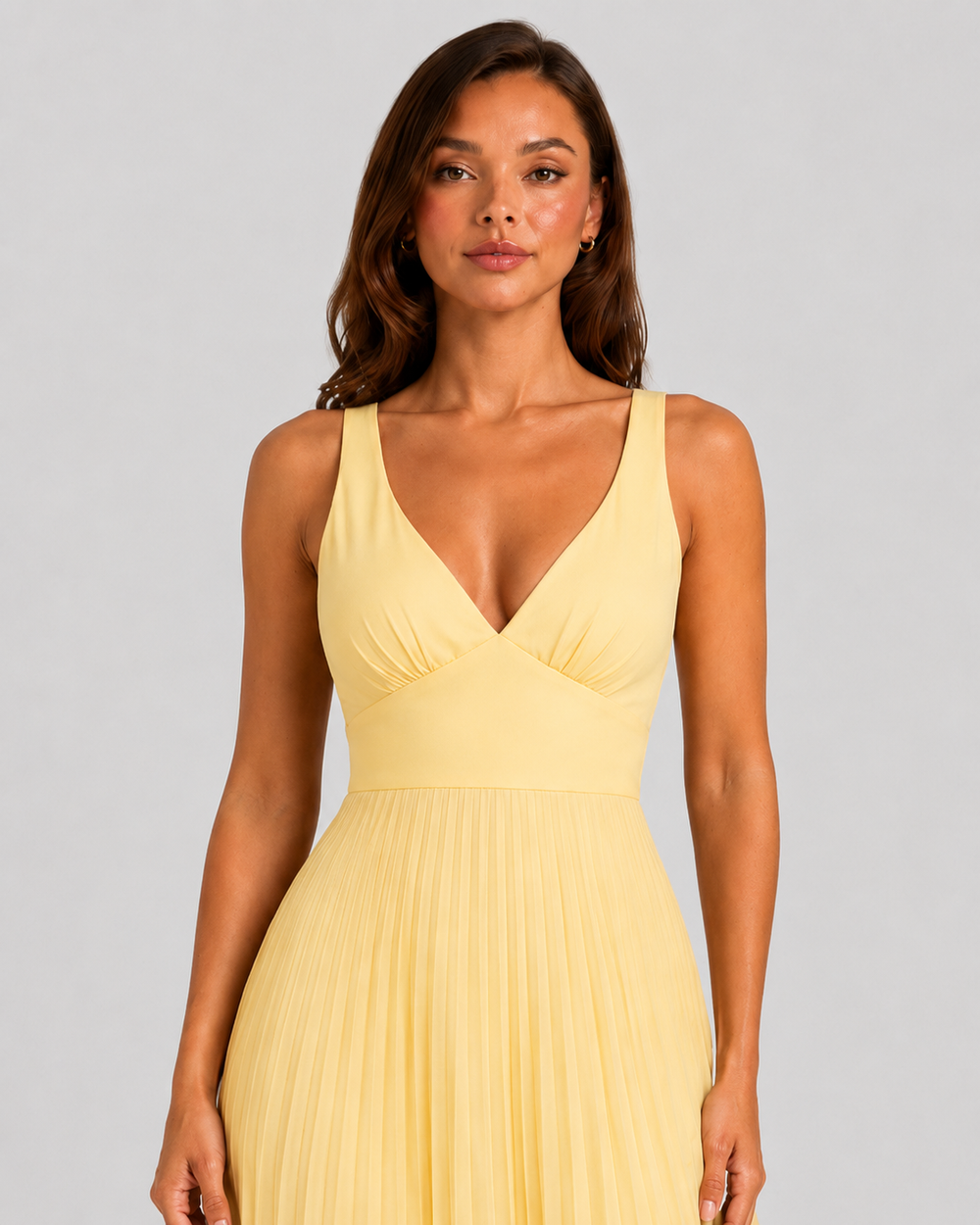 Women's yellow satin-feel pleated maxi dress with defined waist and flowing skirt, elegant occasionwear for weddings, formal events, and summer celebrations.
