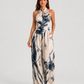 Woman wearing a printed halter neckline wide-leg jumpsuit with a relaxed fit, breathable fabric, side pockets and flowing resort-inspired silhouette.