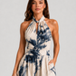 Woman wearing a printed halter neckline wide-leg jumpsuit with a relaxed fit, breathable fabric, side pockets and flowing resort-inspired silhouette.