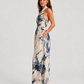 Woman wearing a printed halter neckline wide-leg jumpsuit with a relaxed fit, breathable fabric, side pockets and flowing resort-inspired silhouette.