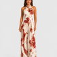 Woman wearing a printed halter neckline wide-leg jumpsuit with a relaxed fit, breathable fabric, side pockets and flowing resort-inspired silhouette.