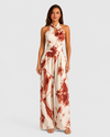 Woman wearing a printed halter neckline wide-leg jumpsuit with a relaxed fit, breathable fabric, side pockets and flowing resort-inspired silhouette.