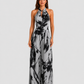 Woman wearing a printed halter neckline wide-leg jumpsuit with a relaxed fit, breathable fabric, side pockets and flowing resort-inspired silhouette.
