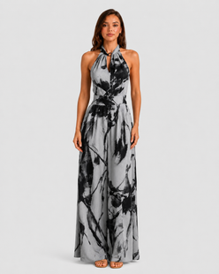 Woman wearing a printed halter neckline wide-leg jumpsuit with a relaxed fit, breathable fabric, side pockets and flowing resort-inspired silhouette.