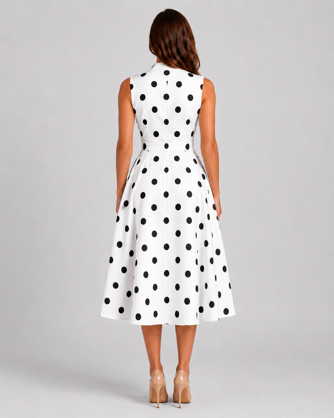 Women's black and white polka dot midi dress with sleeveless V-neckline, waist tie detail, and flowing full skirt in a vintage-inspired silhouette.