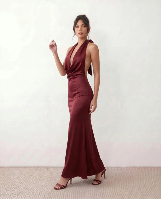 Shop the Women's Georgina Satin Cowl Neck Halter Maxi Dress. Featuring glossy satin, a draped halter neckline, open tie-back design, and a flattering mermaid silhouette, this elegant floor-length gown is perfect for weddings, black-tie events, proms, galas, and special occasions.