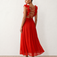 Woman wearing the Giedre Lace-Up A-Line Midi Dress featuring a deep V-neckline, ruffle shoulder sleeves, side waist cut-outs, adjustable lace-up open back and a flowing A-line midi skirt, ideal for weddings, race days and special occasions.