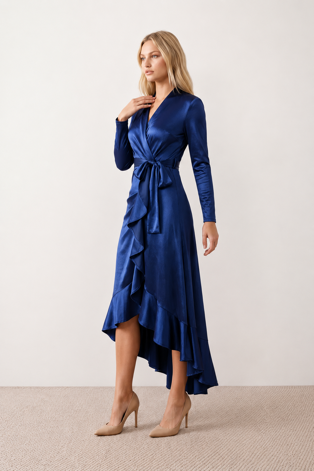 Woman wearing the Cordula Glossy Ruffle Detail Maxi Dress in a satin-look finish featuring a wrap V-neckline, long sleeves, self-tie waist sash and cascading asymmetric ruffle high-low hem, styled as an elegant wedding guest and occasion dress.