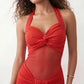 Woman wearing the  Halter Neck Mermaid Maxi Dress featuring a sweetheart twist-knot neckline, sheer mesh waist panel, ruched mermaid silhouette, draped front skirt, open back with halter tie fastening, and elegant floor-length finish.