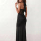 Woman wearing the Halter Neck Mermaid Maxi Dress featuring a sweetheart twist-knot neckline, sheer mesh waist panel, ruched mermaid silhouette, draped front skirt, open back with halter tie fastening, and elegant floor-length finish.