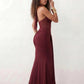 Woman wearing the Halter Neck Mermaid Maxi Dress featuring a sweetheart twist-knot neckline, sheer mesh waist panel, ruched mermaid silhouette, draped front skirt, open back with halter tie fastening, and elegant floor-length finish.