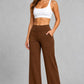 Women's high-waist straight-leg stretch trousers in smooth fabric with elastic waistband and side pockets, offering a flattering tailored fit and all-day comfort.