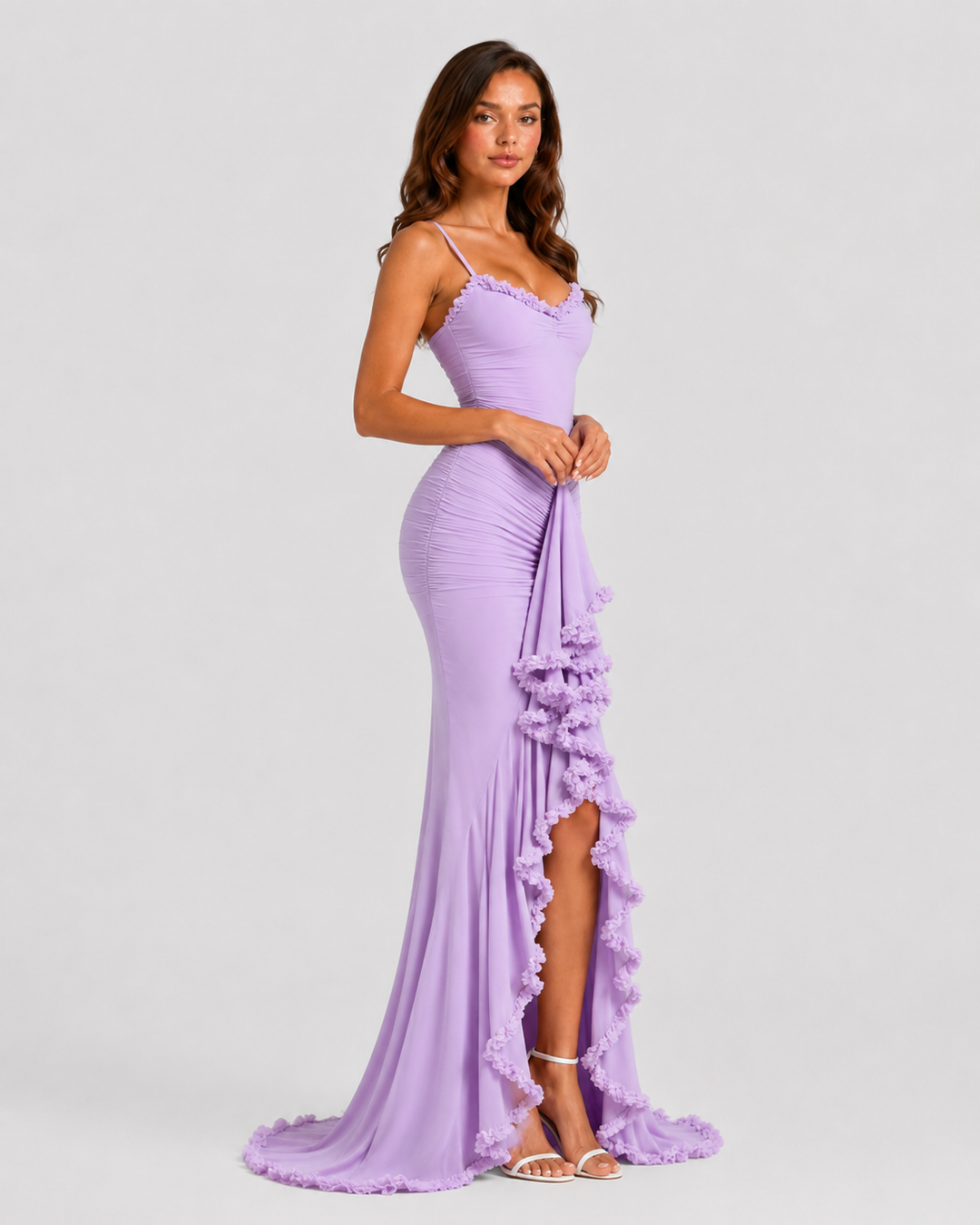 Woman wearing a spaghetti strap bodycon maxi dress with cascading ruffle detailing, high side split, and flowing hem for an elegant evening occasion look.