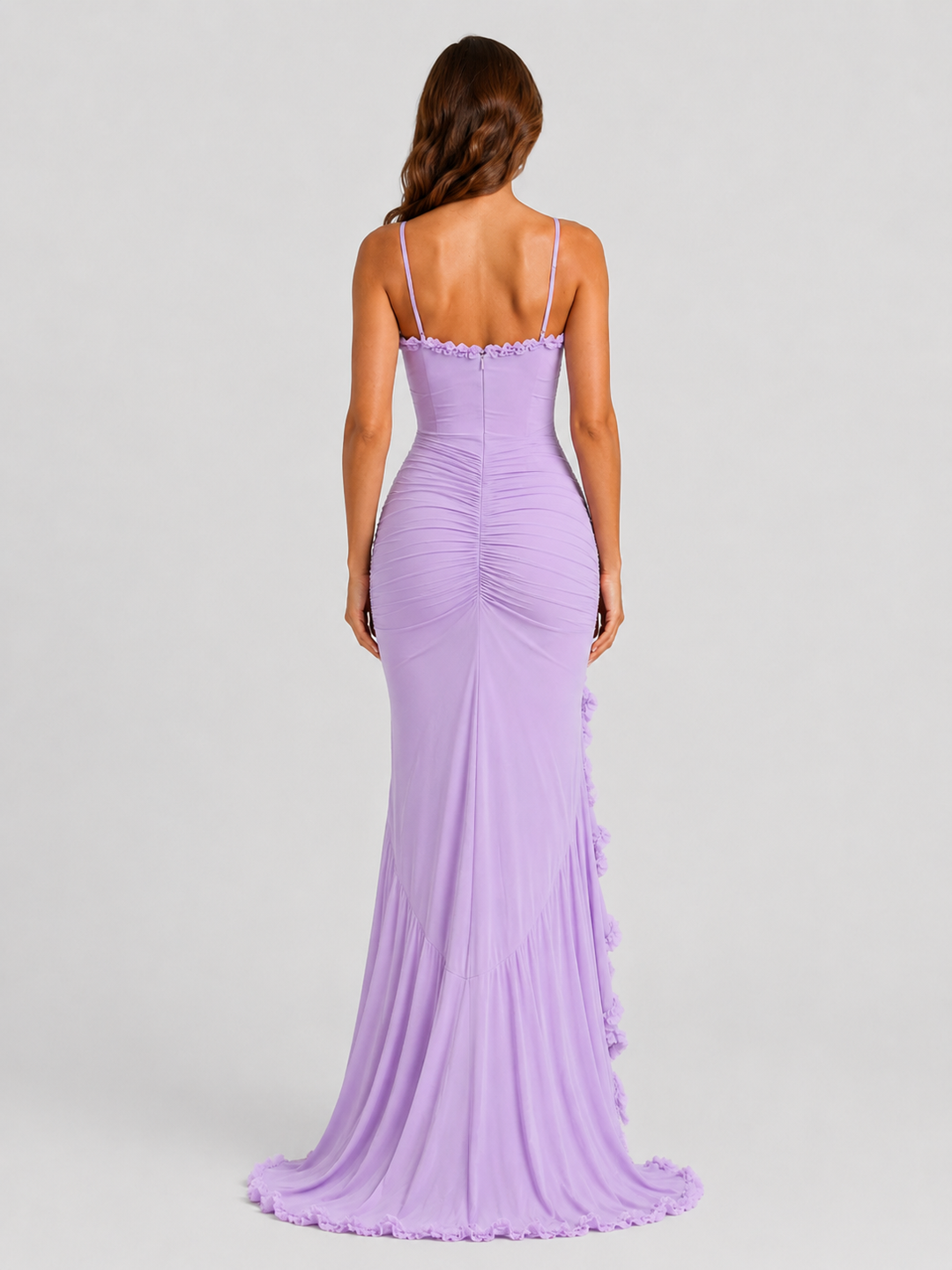 Woman wearing a spaghetti strap bodycon maxi dress with cascading ruffle detailing, high side split, and flowing hem for an elegant evening occasion look.