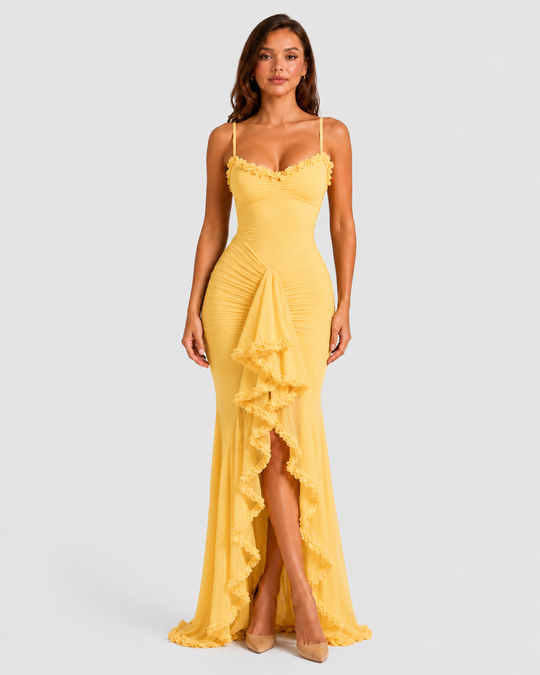 Woman wearing a spaghetti strap bodycon maxi dress with cascading ruffle detailing, high side split, and flowing hem for an elegant evening occasion look.