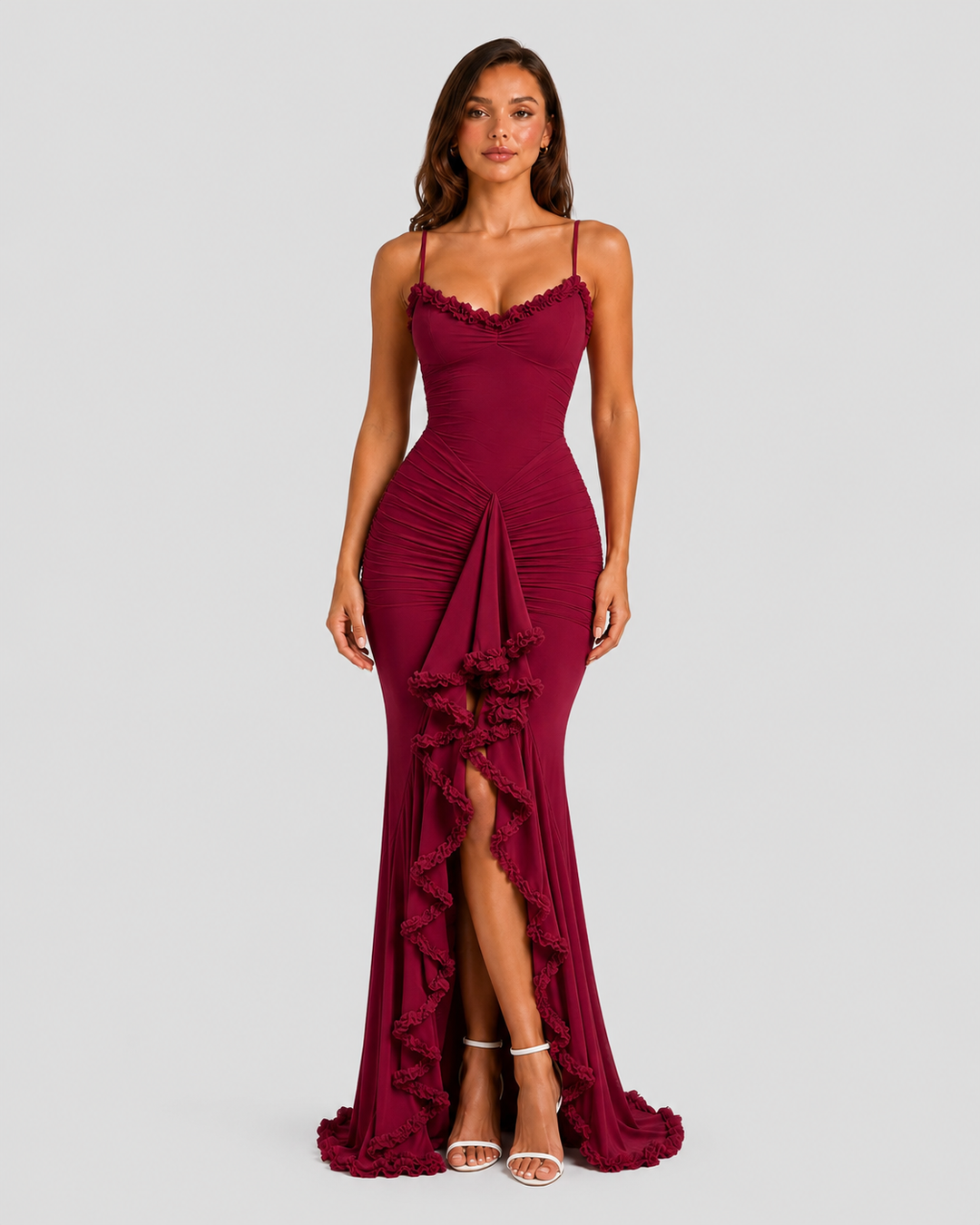 Woman wearing a spaghetti strap bodycon maxi dress with cascading ruffle detailing, high side split, and flowing hem for an elegant evening occasion look.