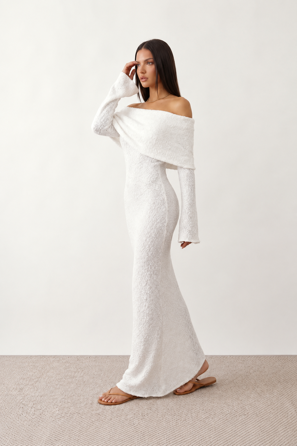 Woman wearing the Iustina Off Shoulder Fitted Maxi Dress featuring a Bardot neckline, soft draped shoulders, full-length sleeves, textured stretch knit fabric and a fitted floor-length silhouette, ideal for formal occasions and evening events.