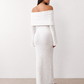 Woman wearing the Iustina Off Shoulder Fitted Maxi Dress featuring a Bardot neckline, soft draped shoulders, full-length sleeves, textured stretch knit fabric and a fitted floor-length silhouette, ideal for formal occasions and evening events.