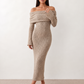Woman wearing the Iustina Off Shoulder Fitted Maxi Dress featuring a Bardot neckline, soft draped shoulders, full-length sleeves, textured stretch knit fabric and a fitted floor-length silhouette, ideal for formal occasions and evening events.