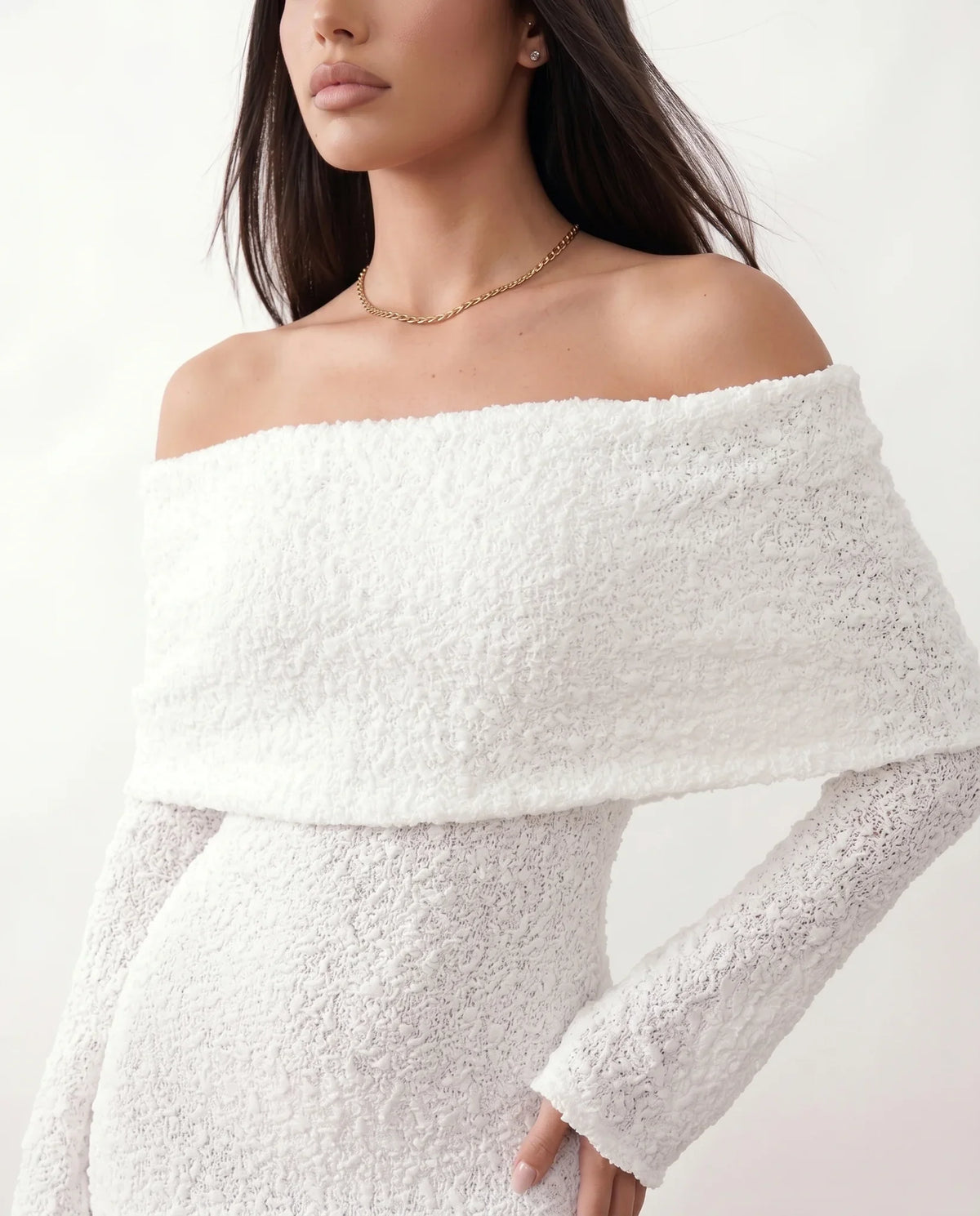 Woman wearing the Iustina Off Shoulder Fitted Maxi Dress featuring a Bardot neckline, soft draped shoulders, full-length sleeves, textured stretch knit fabric and a fitted floor-length silhouette, ideal for formal occasions and evening events.