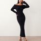 Woman wearing the Iustina Off Shoulder Fitted Maxi Dress featuring a Bardot neckline, soft draped shoulders, full-length sleeves, textured stretch knit fabric and a fitted floor-length silhouette, ideal for formal occasions and evening events.