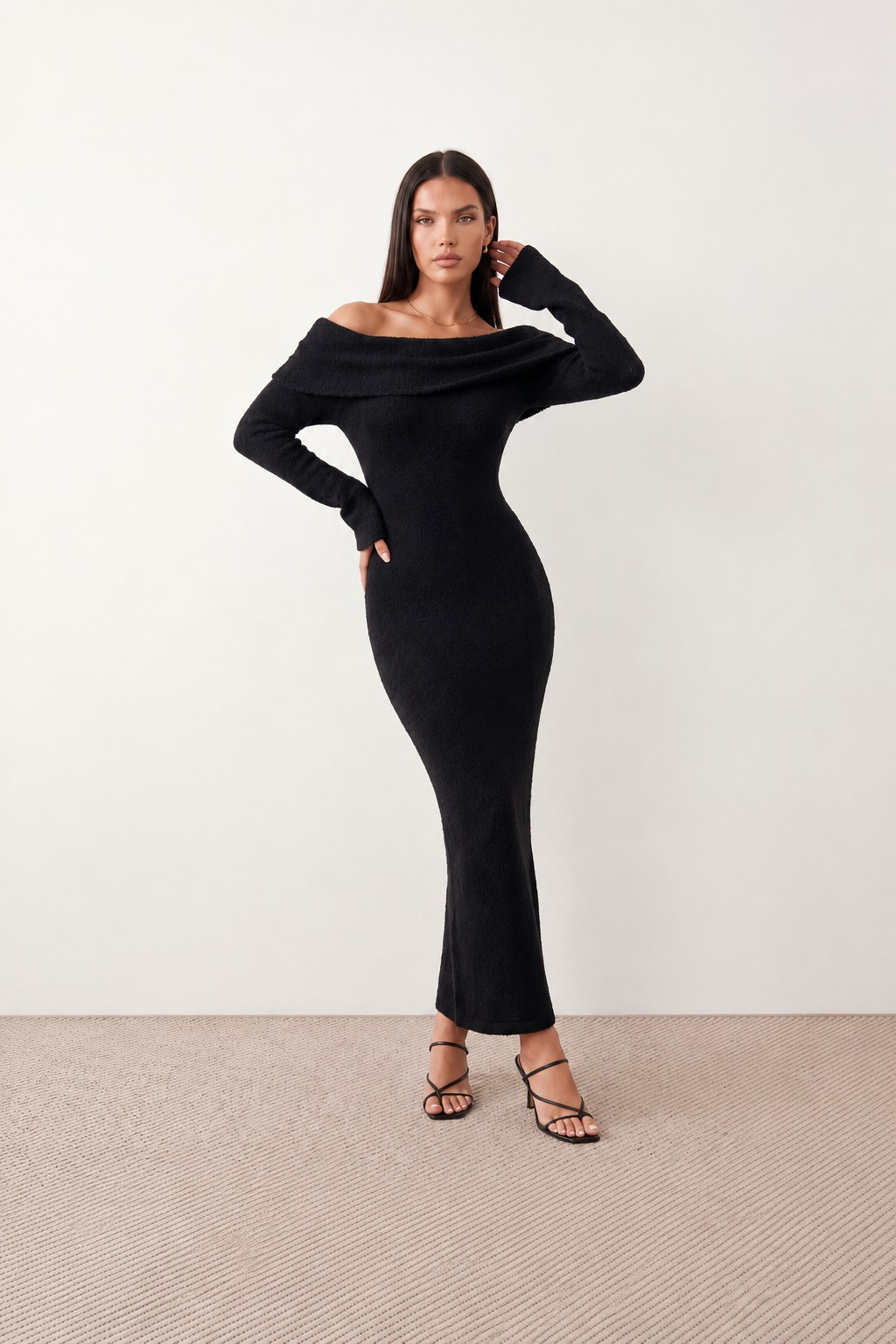 Woman wearing the Iustina Off Shoulder Fitted Maxi Dress featuring a Bardot neckline, soft draped shoulders, full-length sleeves, textured stretch knit fabric and a fitted floor-length silhouette, ideal for formal occasions and evening events.