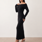 Woman wearing the Iustina Off Shoulder Fitted Maxi Dress featuring a Bardot neckline, soft draped shoulders, full-length sleeves, textured stretch knit fabric and a fitted floor-length silhouette, ideal for formal occasions and evening events.