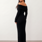 Woman wearing the Iustina Off Shoulder Fitted Maxi Dress featuring a Bardot neckline, soft draped shoulders, full-length sleeves, textured stretch knit fabric and a fitted floor-length silhouette, ideal for formal occasions and evening events.