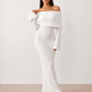 Woman wearing the Iustina Off Shoulder Fitted Maxi Dress featuring a Bardot neckline, soft draped shoulders, full-length sleeves, textured stretch knit fabric and a fitted floor-length silhouette, ideal for formal occasions and evening events.