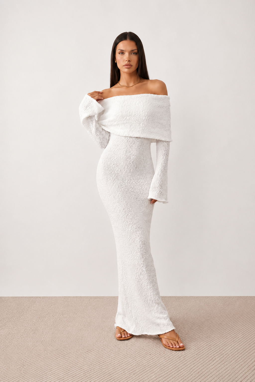 Woman wearing the Iustina Off Shoulder Fitted Maxi Dress featuring a Bardot neckline, soft draped shoulders, full-length sleeves, textured stretch knit fabric and a fitted floor-length silhouette, ideal for formal occasions and evening events.