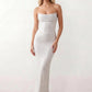 Woman wearing the Izabela sequined strapless maxi dress featuring shimmering all-over sequins, sparkling rhinestone embellishments, a ruched cowl-fold bust, adjustable lace-up corset back and a figure-skimming column silhouette with a floor-length hem, perfect for formal evening occasions.