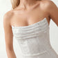 Woman wearing the Izabela sequined strapless maxi dress featuring shimmering all-over sequins, sparkling rhinestone embellishments, a ruched cowl-fold bust, adjustable lace-up corset back and a figure-skimming column silhouette with a floor-length hem, perfect for formal evening occasions.