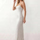 Woman wearing the Izabela sequined strapless maxi dress featuring shimmering all-over sequins, sparkling rhinestone embellishments, a ruched cowl-fold bust, adjustable lace-up corset back and a figure-skimming column silhouette with a floor-length hem, perfect for formal evening occasions.