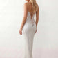 Woman wearing the Izabela sequined strapless maxi dress featuring shimmering all-over sequins, sparkling rhinestone embellishments, a ruched cowl-fold bust, adjustable lace-up corset back and a figure-skimming column silhouette with a floor-length hem, perfect for formal evening occasions.