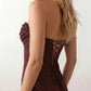 Woman wearing the Izabela sequined strapless maxi dress featuring shimmering all-over sequins, sparkling rhinestone embellishments, a ruched cowl-fold bust, adjustable lace-up corset back and a figure-skimming column silhouette with a floor-length hem, perfect for formal evening occasions.