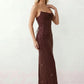 Woman wearing the Izabela sequined strapless maxi dress featuring shimmering all-over sequins, sparkling rhinestone embellishments, a ruched cowl-fold bust, adjustable lace-up corset back and a figure-skimming column silhouette with a floor-length hem, perfect for formal evening occasions.