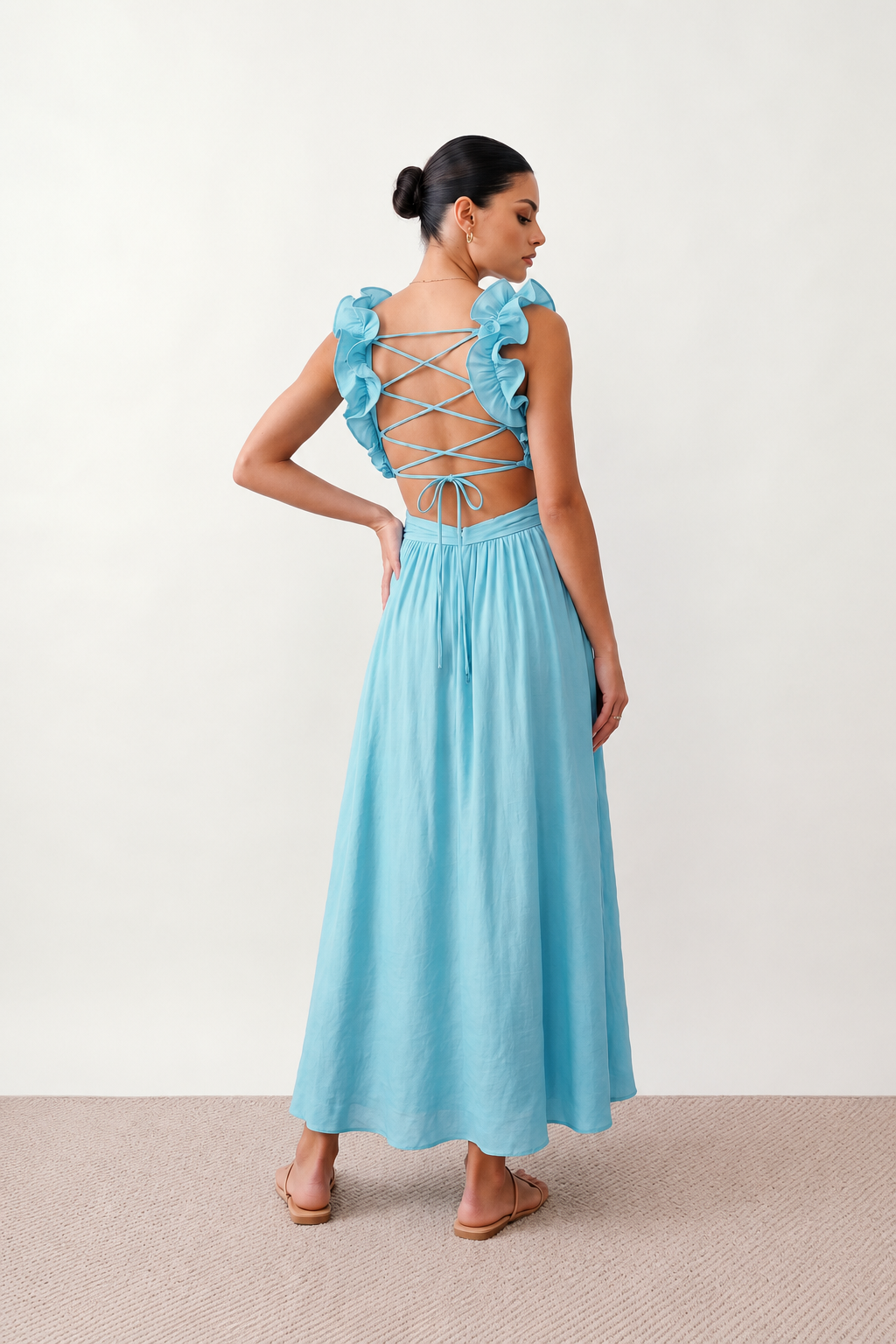 Woman wearing the Giedre Lace-Up A-Line Midi Dress featuring a deep V-neckline, ruffle shoulder sleeves, side waist cut-outs, adjustable lace-up open back and a flowing A-line midi skirt, ideal for weddings, race days and special occasions.